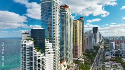 High view of Sunny Isles Beach city with heavy urban traffic and expensive highrise hotels and condo buildings on Atlantic ocean shore. American tourism infrastructure in coastal southern Florida