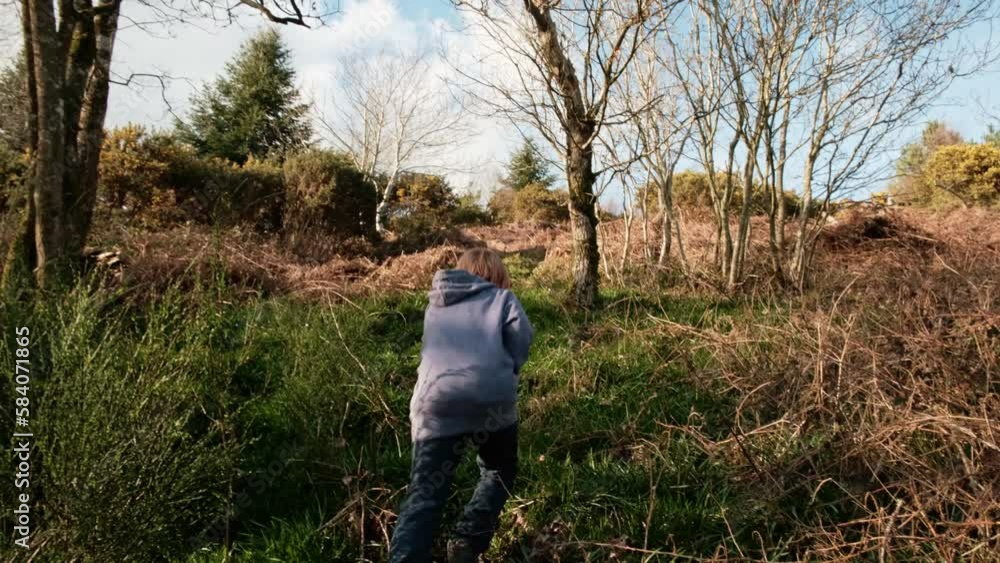 A boy walks on a hill with dry grass. Walking, active recreation, hiking for a child on vacation. A boy walks on a hill with dry grass. Walking, active recreation, hiking for a child on vacation.