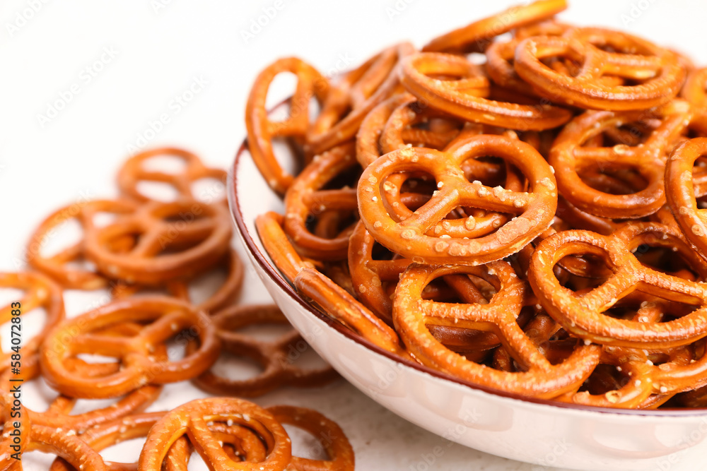 Bowl of tasty salted pretzels on light background, closeup Bowl of tasty salted pretzels on light background, closeup