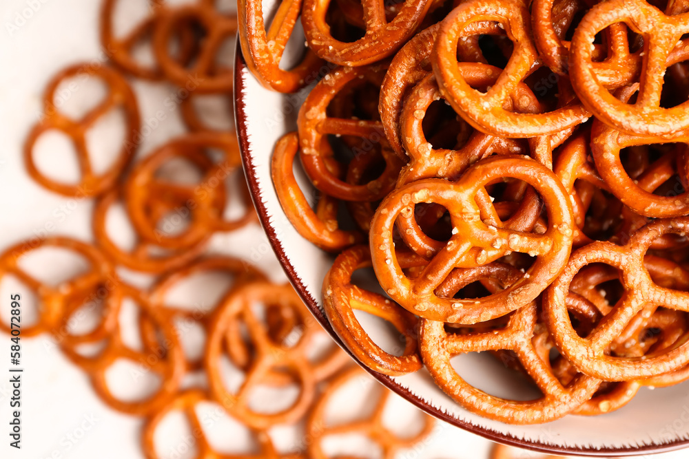 Bowl of tasty salted pretzels on light background, closeup Bowl of tasty salted pretzels on light background, closeup