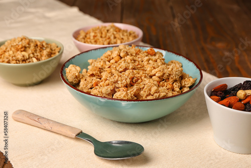 Bowls of tasty granola on wooden background
