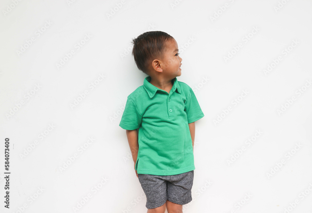 Portrait of a cute little Asian boy smiling and looking at the beside to the white space, isolated on the white background Portrait of a cute little Asian boy smiling and looking at the beside to the white space, isolated on the white background