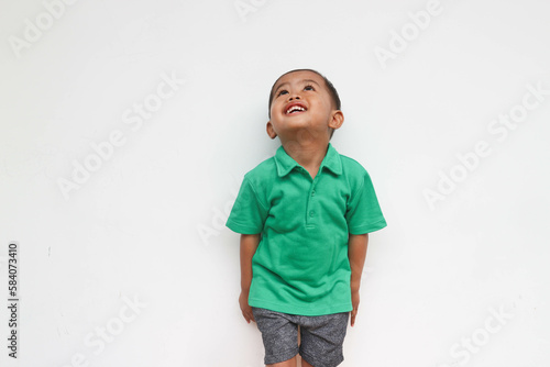 Portrait of a happy little Asian boy curious looking up while smiling, isolated on the white background