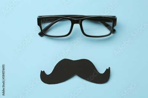 Paper mustache and eyeglasses on color background