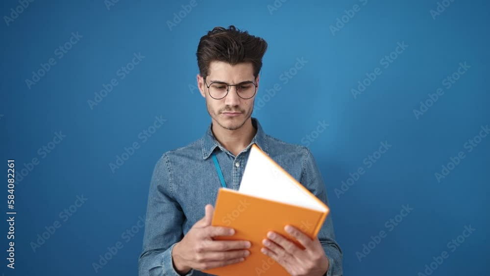 Young hispanic man smiling confident reading book over isolated blue background Young hispanic man smiling confident reading book over isolated blue background