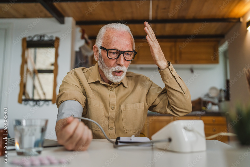 Man senior caucasian male use device to measure blood pressure at home Man senior caucasian male use device to measure blood pressure at home