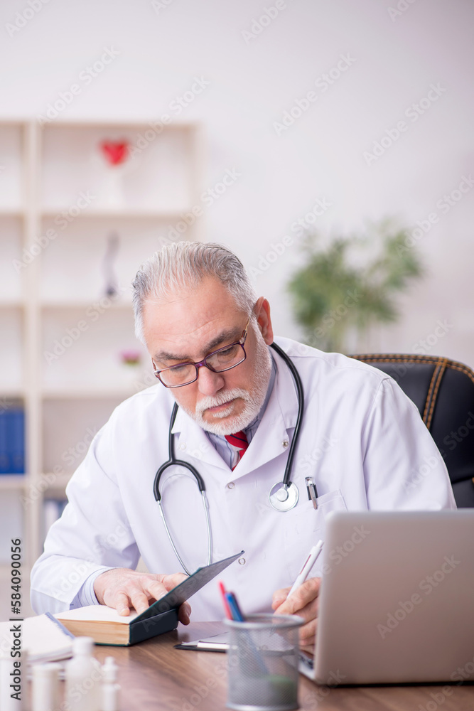 Old male doctor working in the clinic Old male doctor working in the clinic