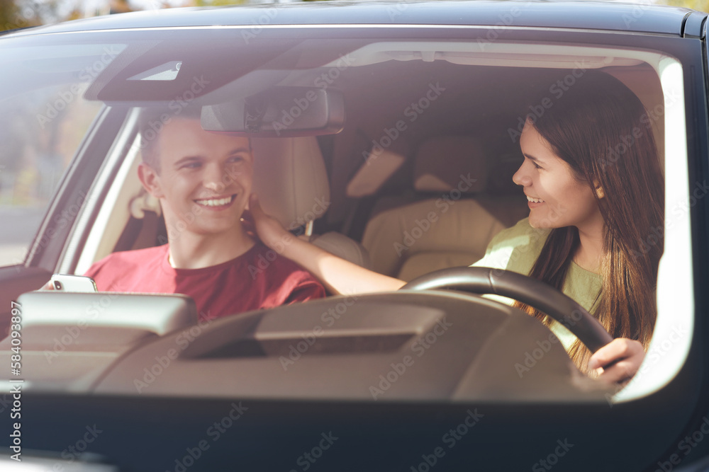 Happy young couple travelling together by car