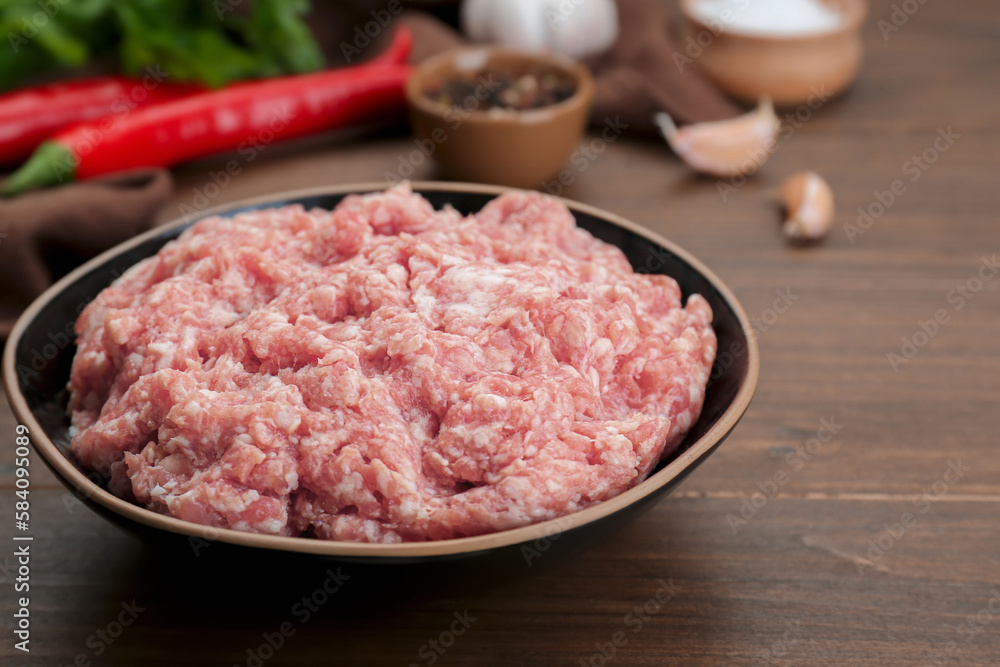 Bowl with raw fresh minced meat on wooden table, closeup Bowl with raw fresh minced meat on wooden table, closeup