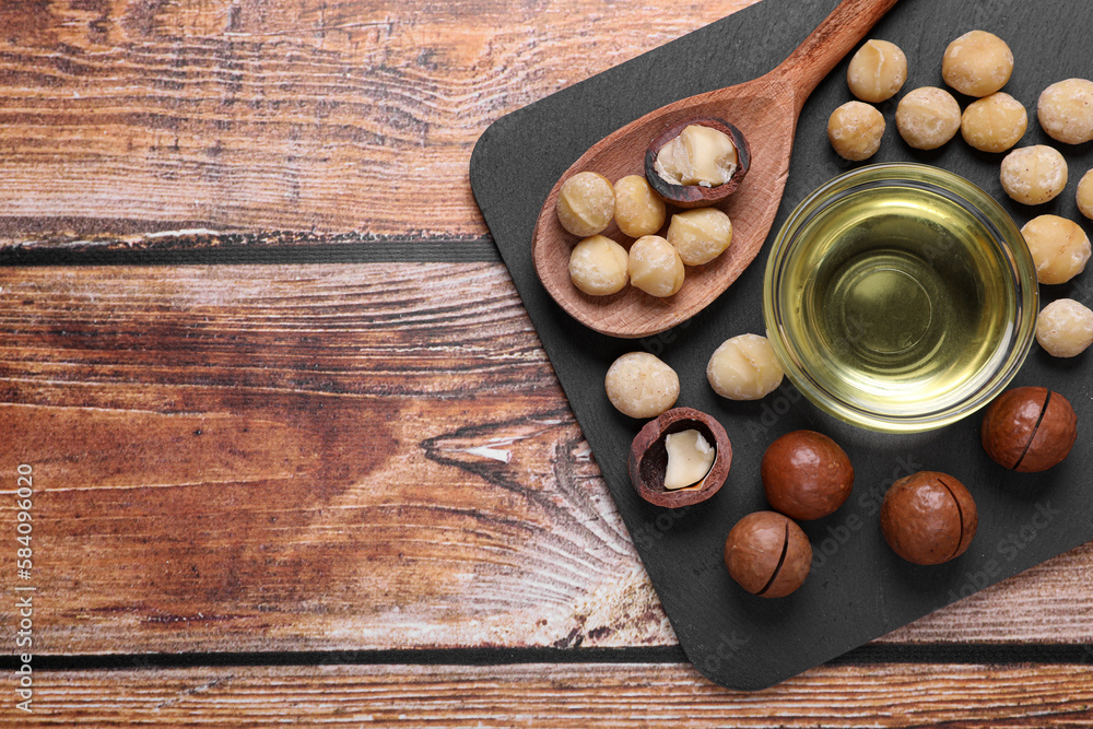 Delicious organic Macadamia nuts and natural oil on wooden table, top view Delicious organic Macadamia nuts and natural oil on wooden table, top view
