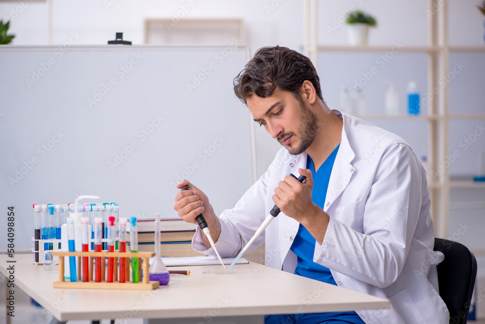 Young male chemist working at the lab Young male chemist working at the lab