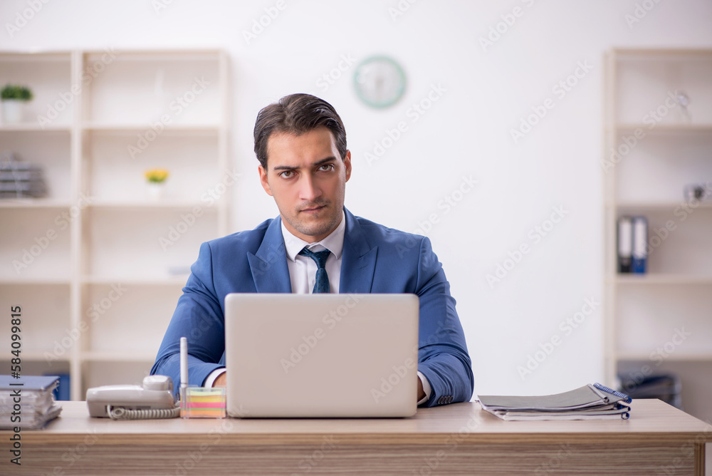 Young male employee working in the office Young male employee working in the office