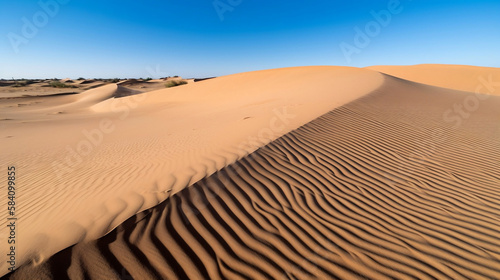 A desert landscape with towering sand dunes  no vegetation  and a clear blue sky.