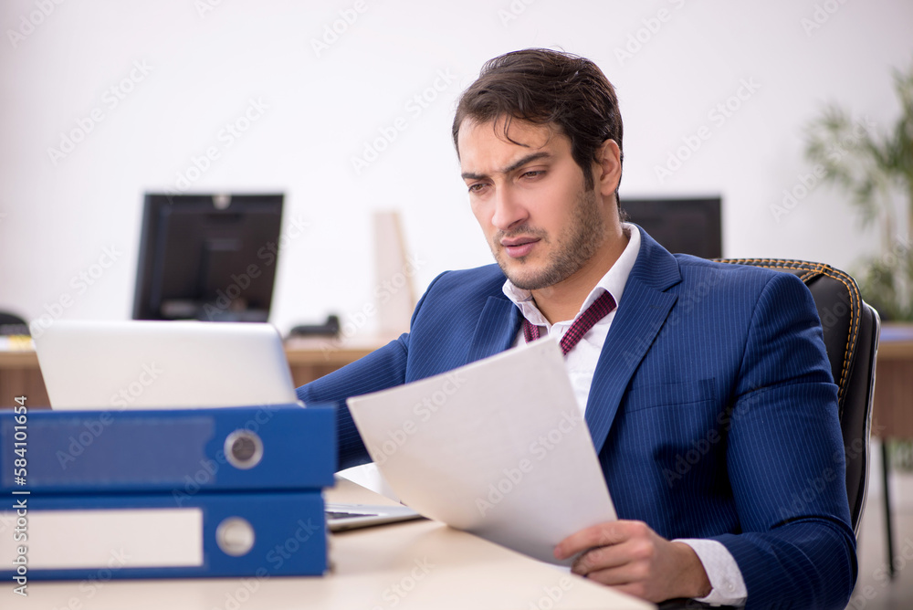 Young male employee working in the office Young male employee working in the office