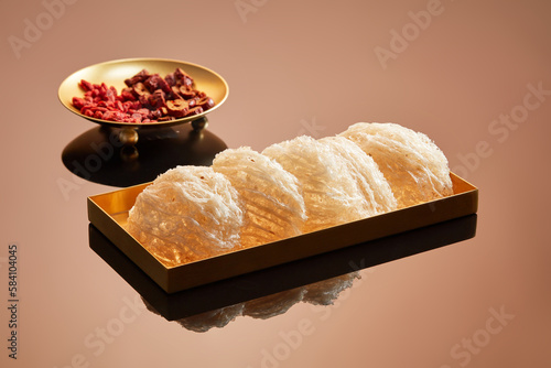 Edible bird’s nest placed on a golden dish decorated with a dish of jujube and dried goji berries. Health and skin condition can be enhanced by eating bird’s nest with herbs photo