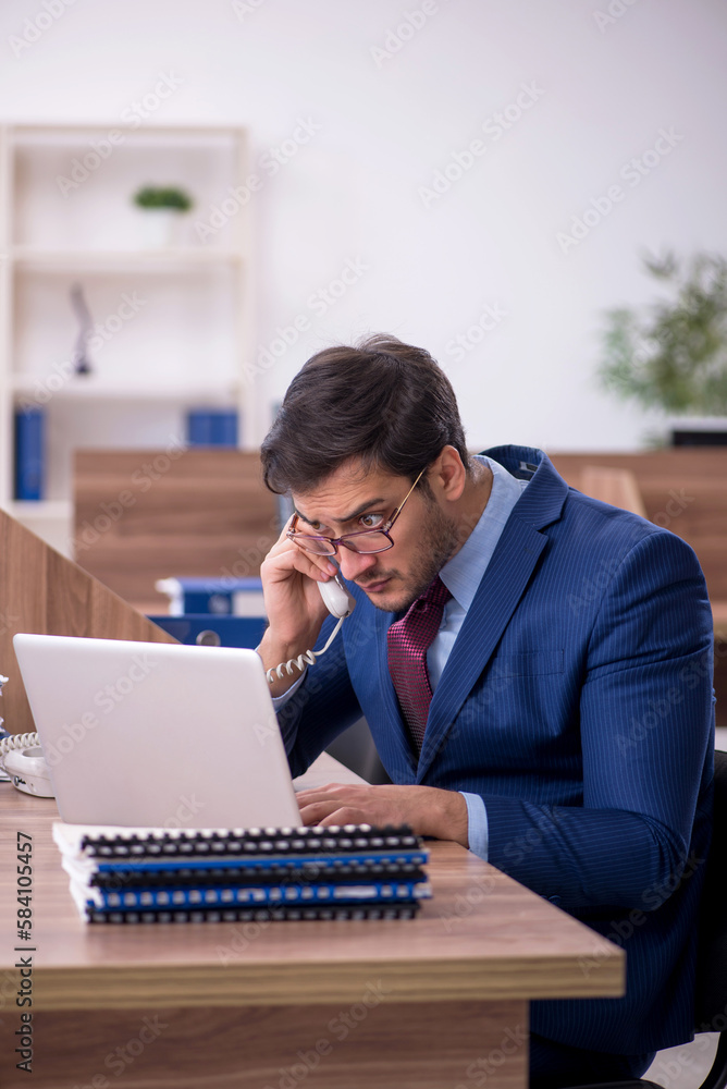 Young male employee working in the office Young male employee working in the office