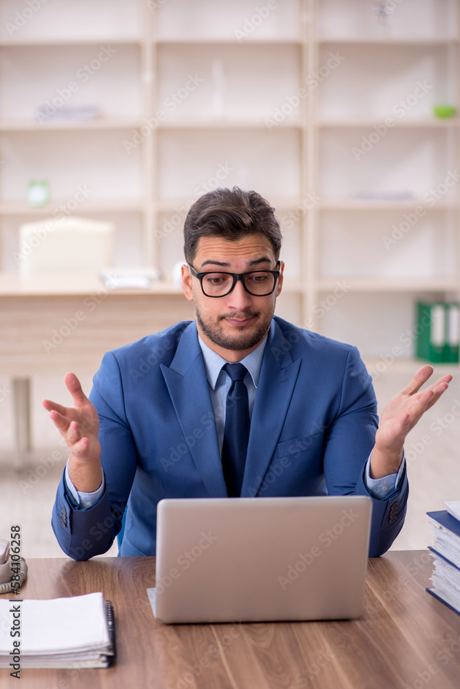Young male employee working in the office Young male employee working in the office