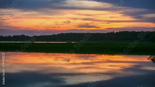 Wallpaper Mural Reflection of the sky in the water of a lake next to a road. Orange sky timelapse at sunset. Torontodigital.ca