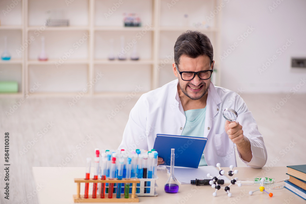 Young male chemist sitting at the lab Young male chemist sitting at the lab