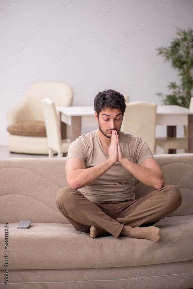 Fototapeta premium Young man sitting at home during pandemic