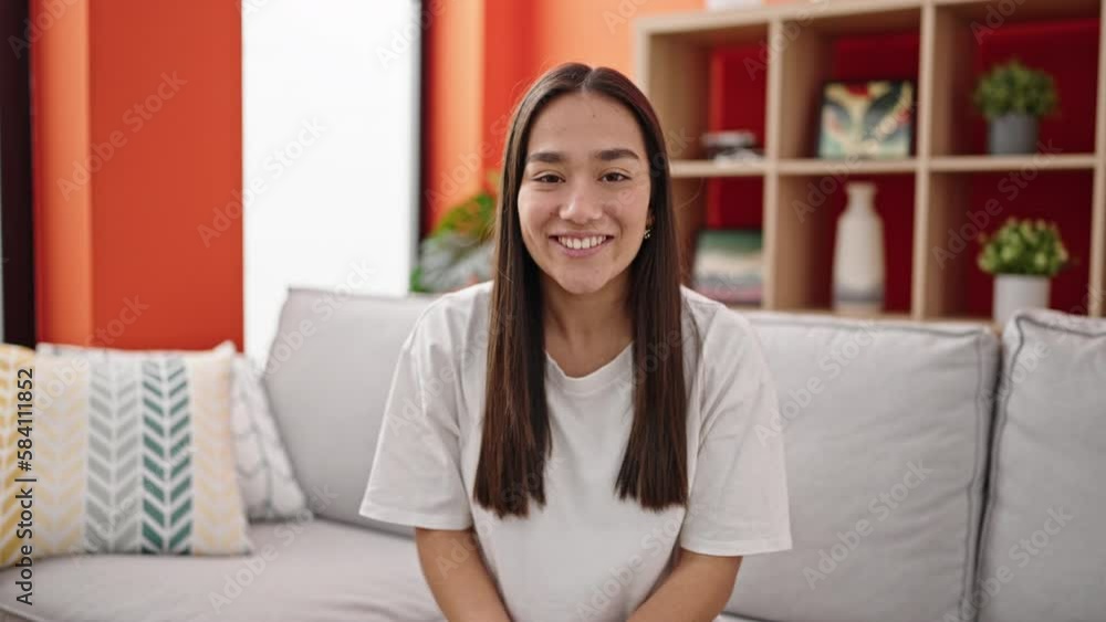 Young beautiful hispanic woman having video call sitting on sofa at home Young beautiful hispanic woman having video call sitting on sofa at home