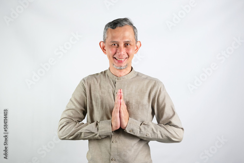 Portrait Asian Moslem Man with greetings and welcoming gestures, smiling face
 photo