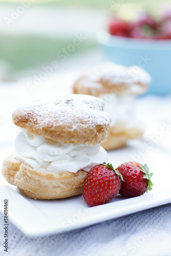 pastry on a white plate with whipped cream and strawberries