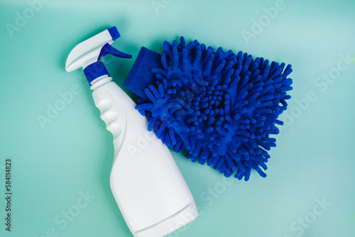 Eco-friendly glass cleaner and wash mitt on  microfiber. Cleans car, glass, mirrors without streking. Safely cleans dirt, dust and greasy fingerprints. Spray bottle on a light blue background.  photo