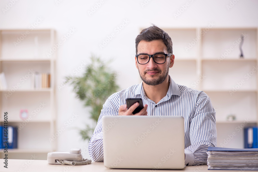 Young male employee working in the office Young male employee working in the office