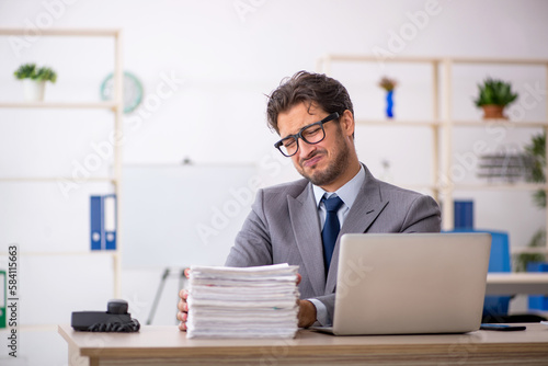 Young male employee sitting at workplace