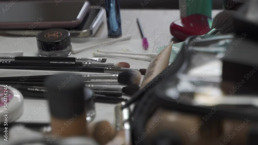 Various utensils for make-up and small makup bags on a table, among other things, brushes