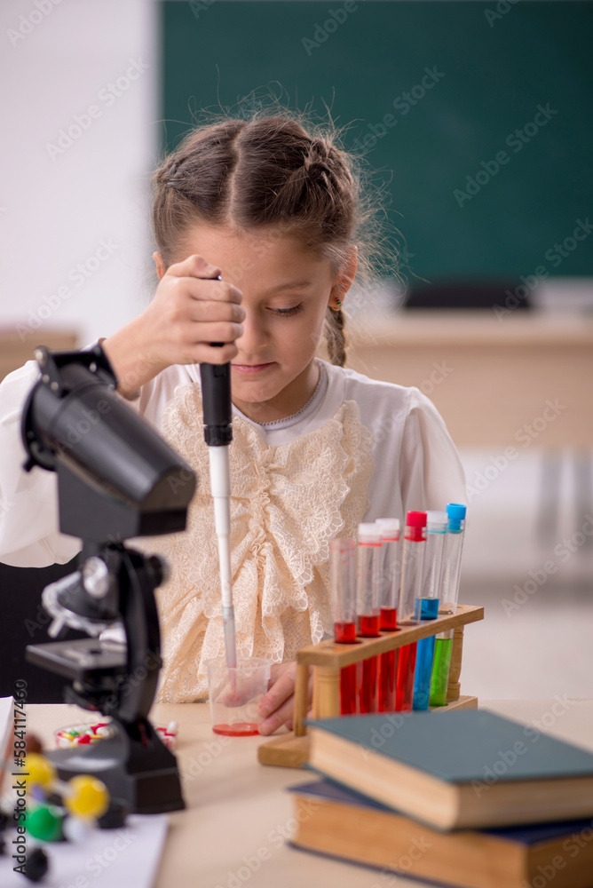 Small girl studying chemistry in the classroom Small girl studying chemistry in the classroom