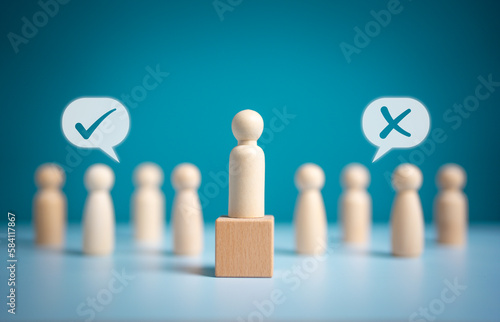 фотографія Wooden figures peg dolls stand above wooden cube among others with vote yes or no symbol