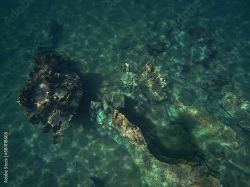 A rough rock below the water in Coron, Palawan in the Philippines with water reflecting the light.