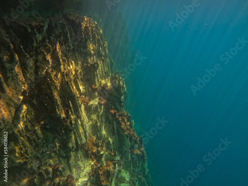 A rough rock below the water in Coron, Palawan in the Philippines with water reflecting the light. © Monika