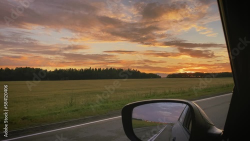 ride in a car in the summer along a country road to meet the sunset