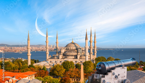 Ramadan Concept - Sultanahmet mosque and Bosphorus with crescent moon and cannon at bright blue sky - Istanbul, Turkey