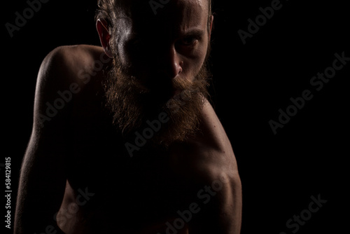 Angry hipster in dramatic photo on black background in studio. Expression and fashion