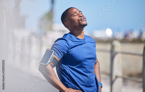 Fitness, training and tired man runner outdoors for break from exercise, cardio or running on blurred background. Workout, stop and breathe by athletic male outside for marathon, run or sport routine