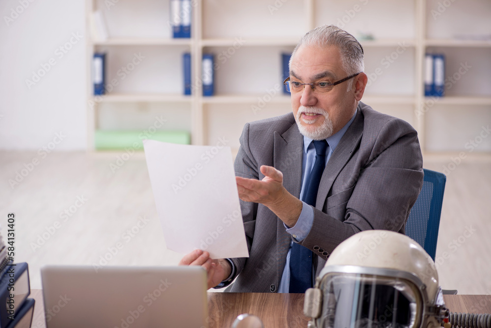Old male employee wearing spacesuit in the office Old male employee wearing spacesuit in the office