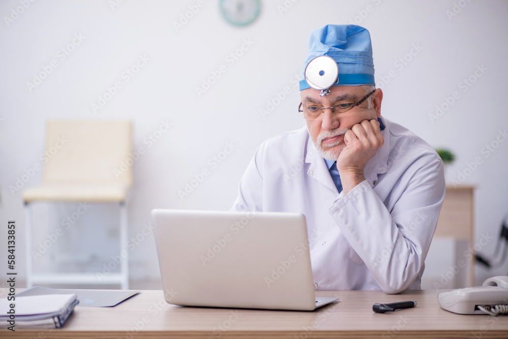 Old male docror otolaryngologist working in the clinic Old male docror otolaryngologist working in the clinic