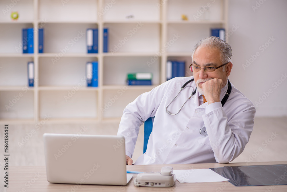 Old male doctor working in the clinic Old male doctor working in the clinic