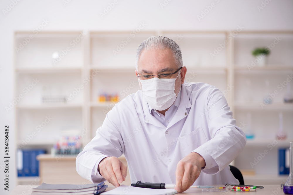 Old male chemist working at the lab Old male chemist working at the lab