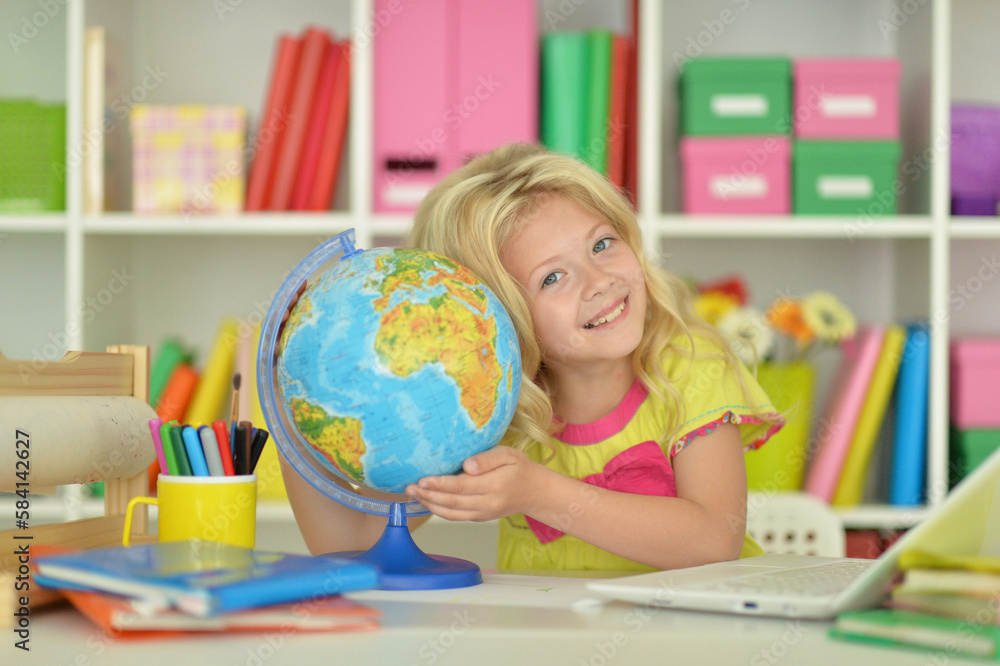 girl studying with a globe at the table girl studying with a globe at the table