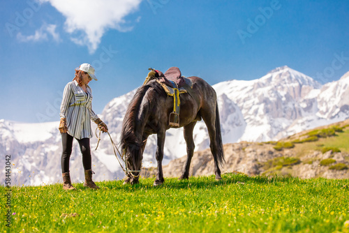 Girl with a horse in nature in the mountains. Horseback riding in the reserve.