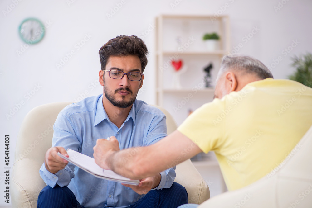 Obraz premium Old man visiting young male psychotherapist