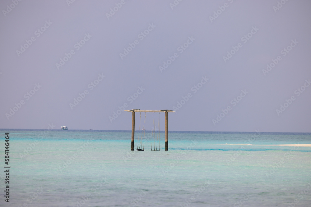 Swing with Beautiful Sun Sea Sand and Sky in Maldive, luxury tropical resort, turquoise transparent sea a, summer time, Nature Background Swing with Beautiful Sun Sea Sand and Sky in Maldive, luxury tropical resort, turquoise transparent sea a, summer time, Nature Background