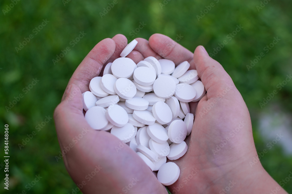 A handful of white round pills in his hands. Medications. Pills. A handful of white round pills in his hands. Medications. Pills.
