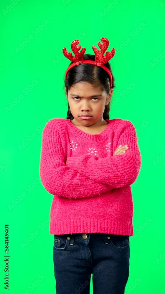 Face, Christmas and an unhappy girl on a green screen background standing arms crossed in anger. Kids, sad and frustrated with a miserable little female child looking moody, annoyed or upset Face, Christmas and an unhappy girl on a green screen background standing arms crossed in anger. Kids, sad and frustrated with a miserable little female child looking moody, annoyed or upset