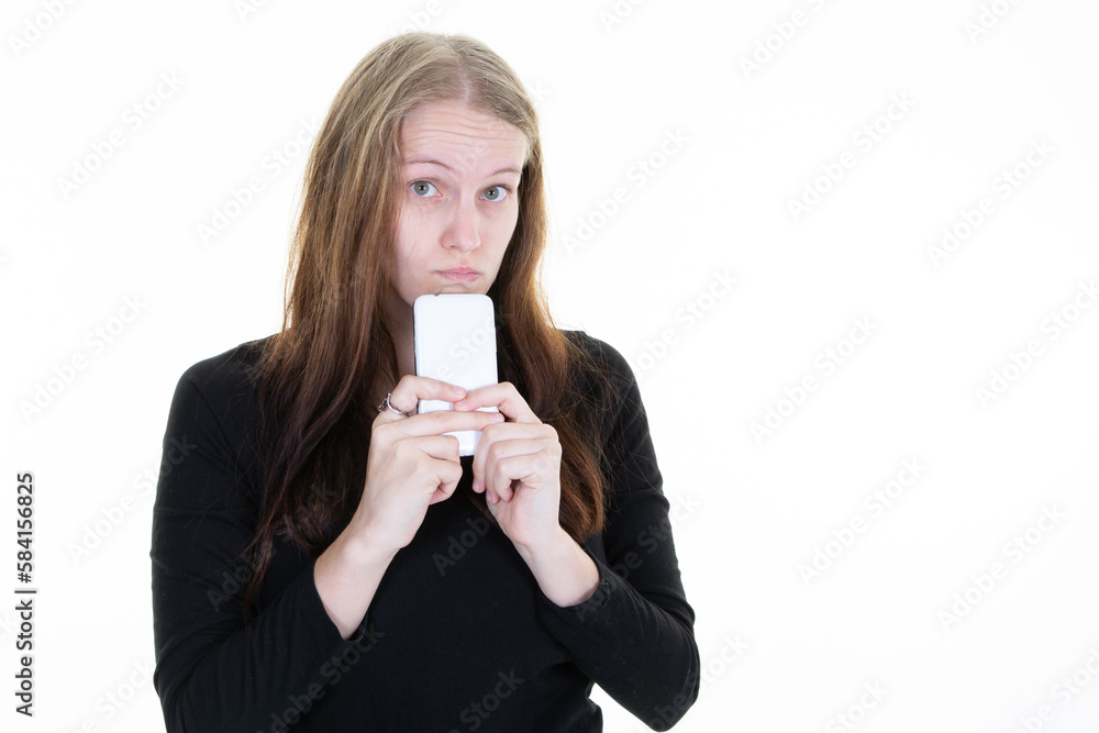 portrait of young pretty woman holding a mobile phone in her hand making a grimace of doubt smartphone on chin portrait of young pretty woman holding a mobile phone in her hand making a grimace of doubt smartphone on chin